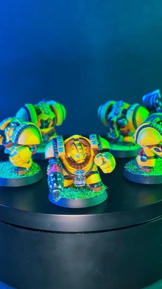 Group of miniatures with bright glowing bases photographed under coloured light