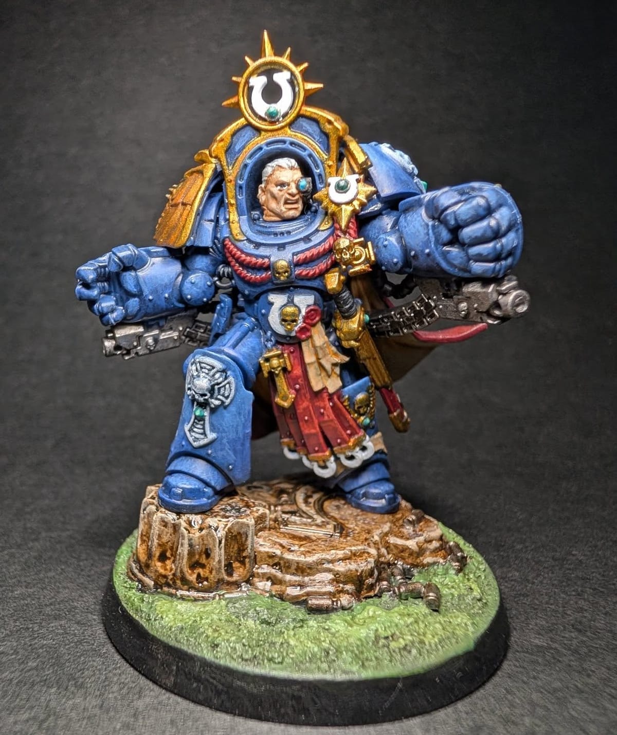 Space Marine Captain miniature in blue armour with gold trim and a laurel