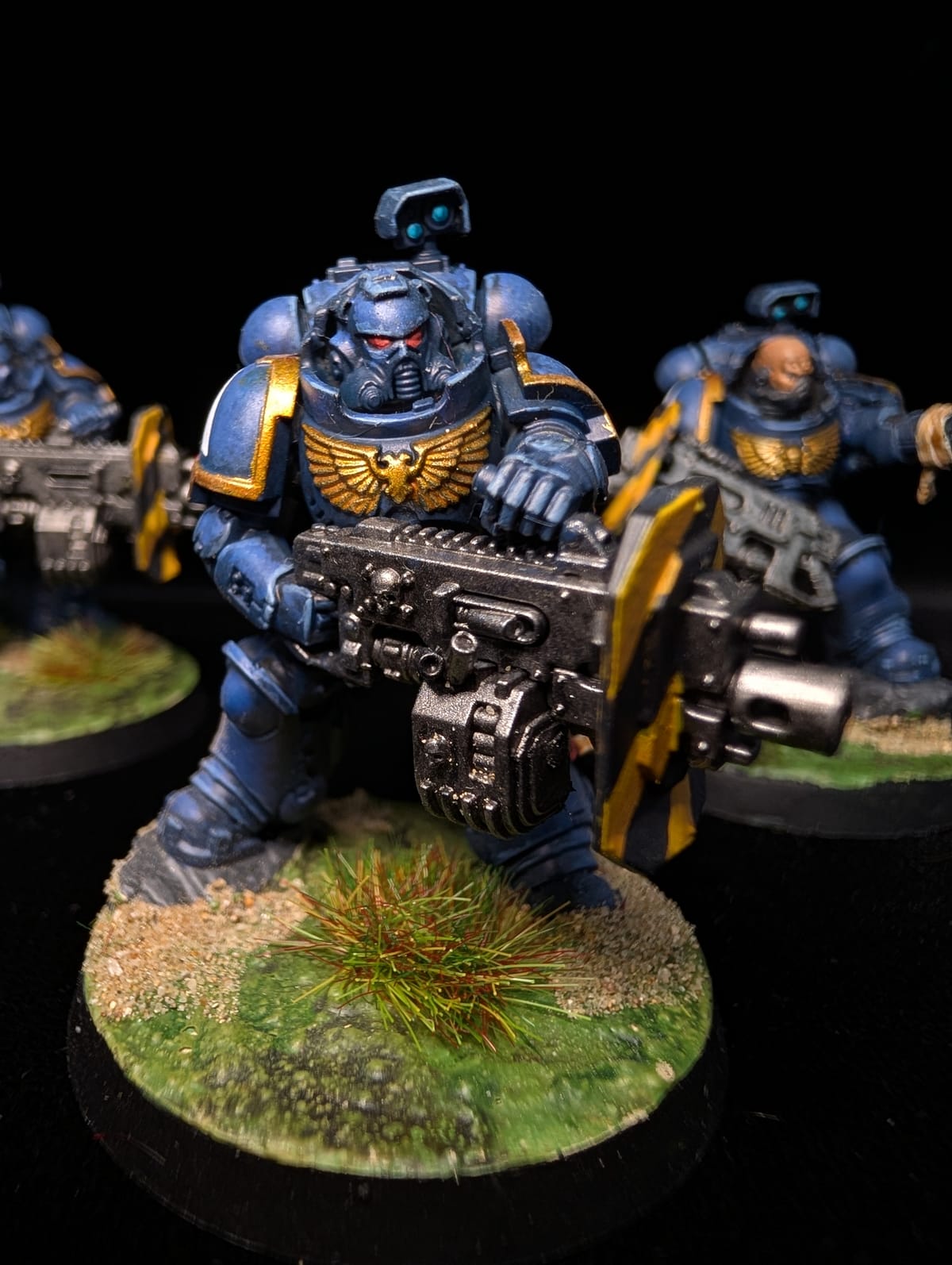 Squad of Ultramarines Primaris Eradicators in blue armour with heavy weapons, on grassy bases