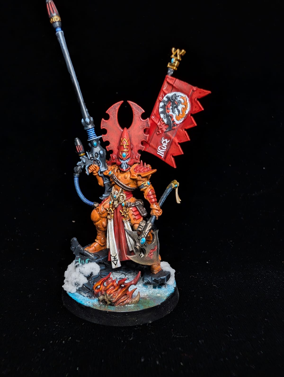 Aeldari Phoenix Lord Fuegan in orange and red armour with a firepike and a red banner, on a snow base