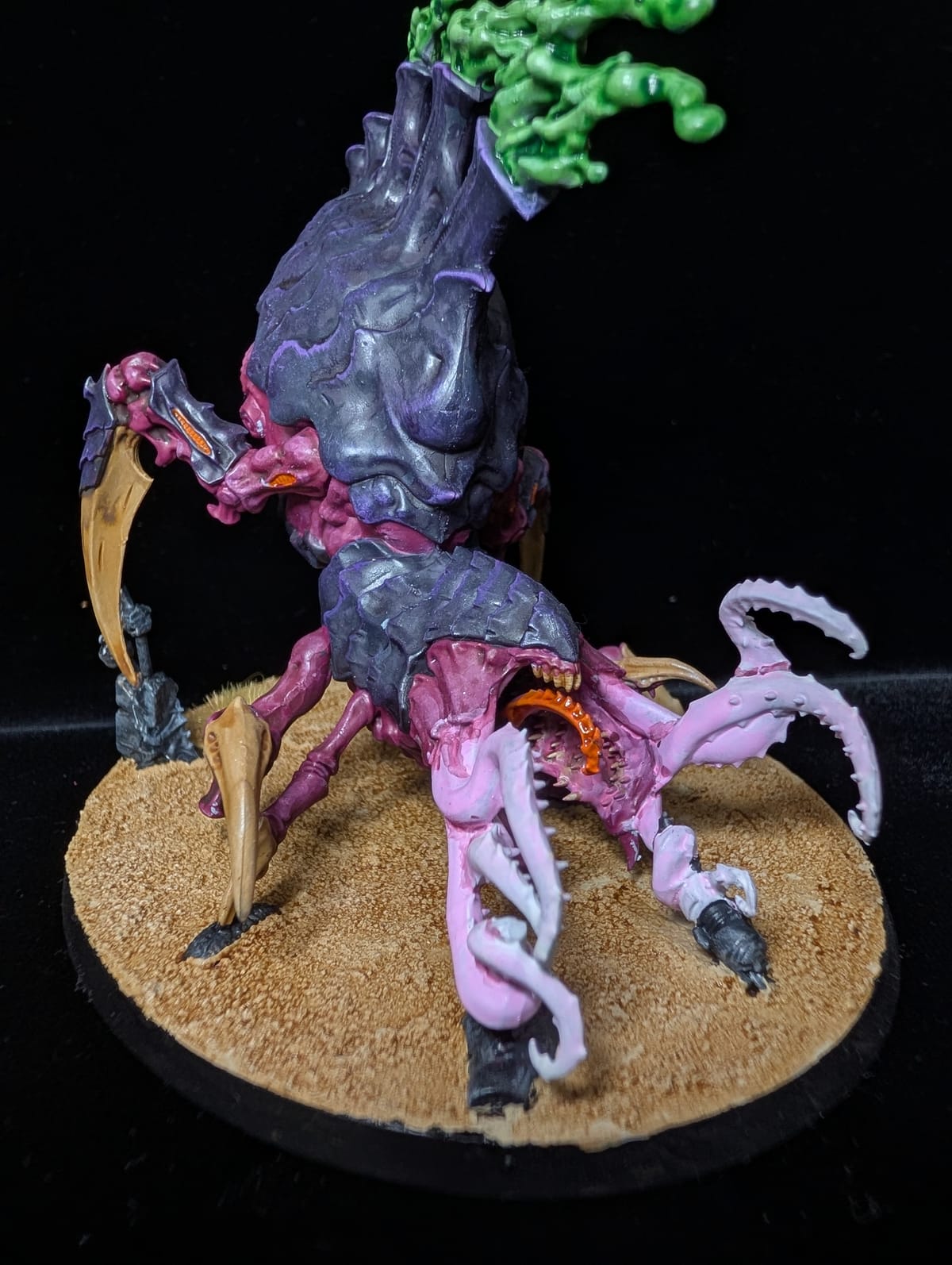 Tyranid Psychophage in purple with pink tentacles and a green crest, on a sandy base